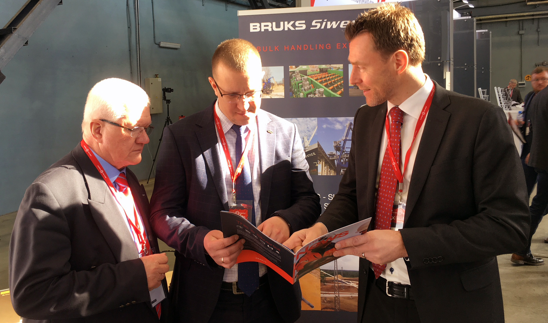 One person showing two persons a brochure