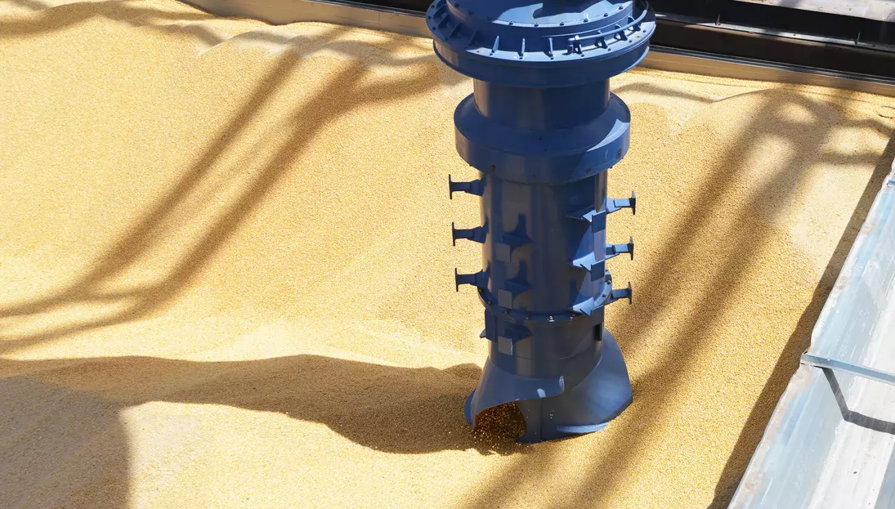 Closeup of Inlet feeder and vertical screw conveyor unloading grain from barge