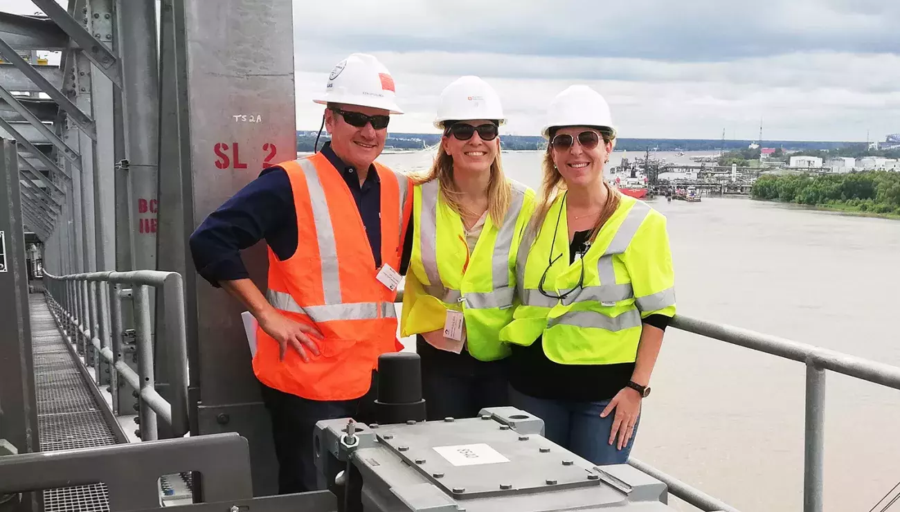 Three persons standing on the ADM shiploader