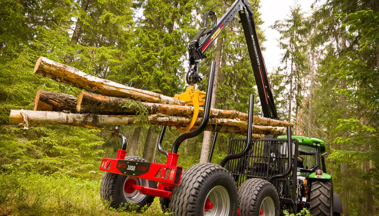 Forest crane lifting logs in forest