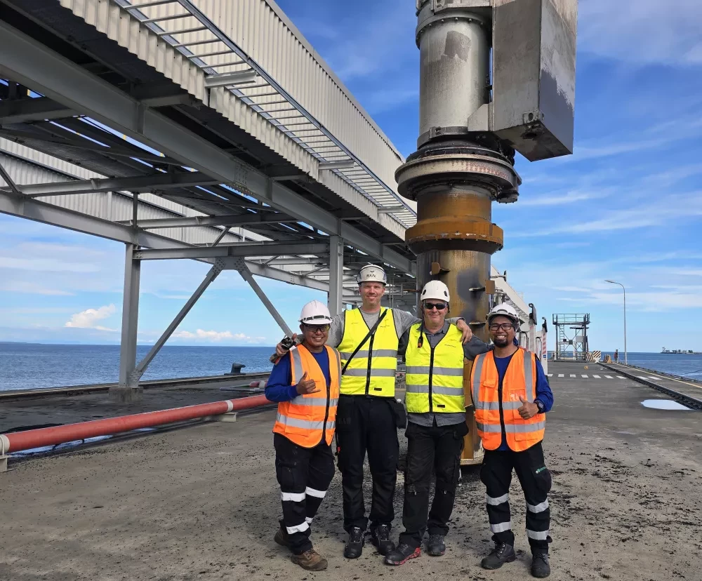 four people infront of a Siwertell ship unloader