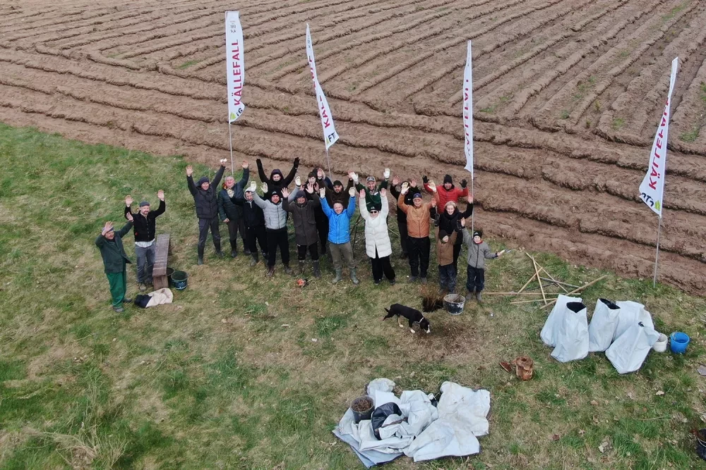 People standing with their hands up in cheerful mode in front of field