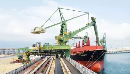 Continuous shipunloader on quay next to ship with water in background